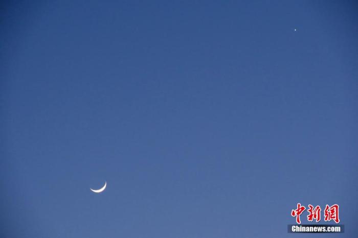 资料图：此前，北京，天气晴好，太阳落山之后，天宇“金星合月”天文景观清晰可见。/p中新社记者 孙自法 摄