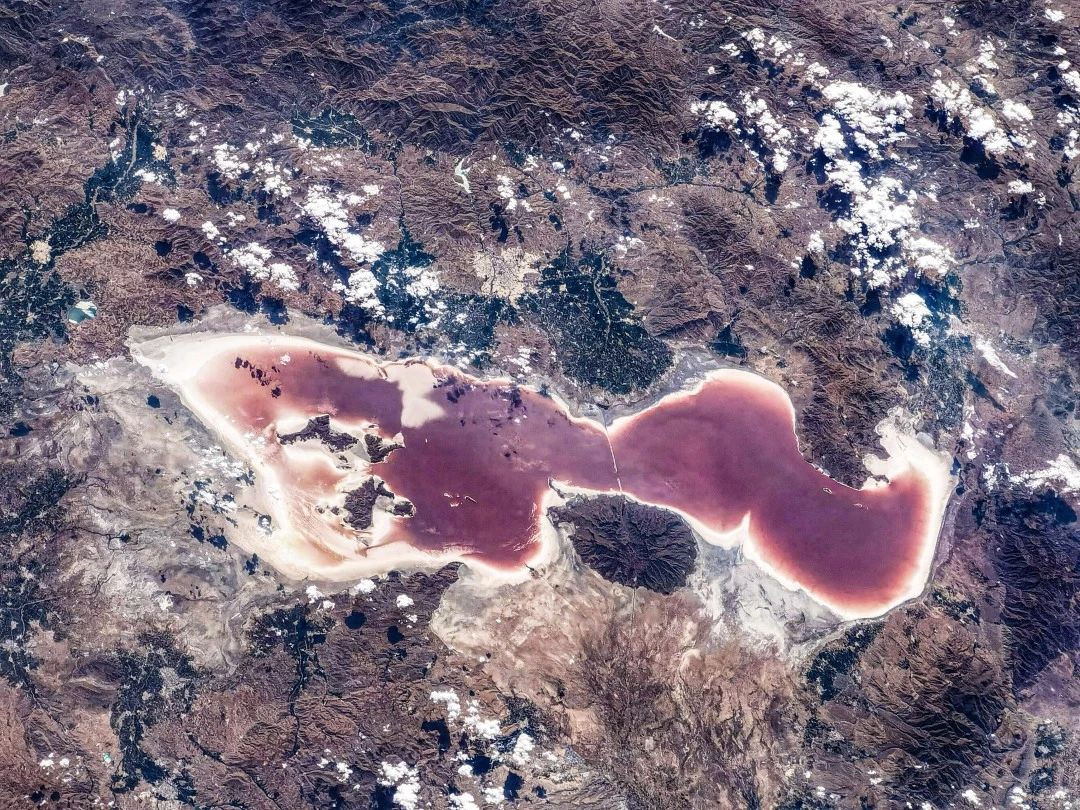 世界第二大的咸水湖——乌鲁米耶湖，在7月的高温下，水分加速蒸发，水中的盐生杜氏藻产生胡萝卜素使整个乌鲁米耶湖呈现出迷人的锈红色，被白色盐滩包围的湖泊尽管美得令人心醉，但这红色却是她在干涸威胁下的呼救。航天员刘伯明摄