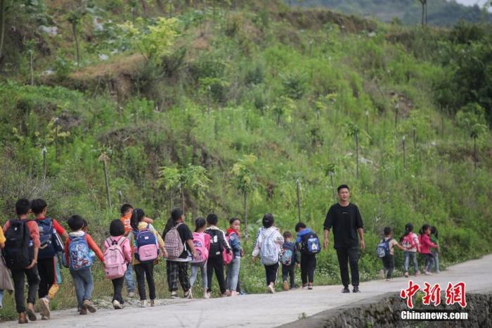 资料图：一名“90后”乡村教师组织学生排队上下学。 /p中新社记者 瞿宏伦 摄